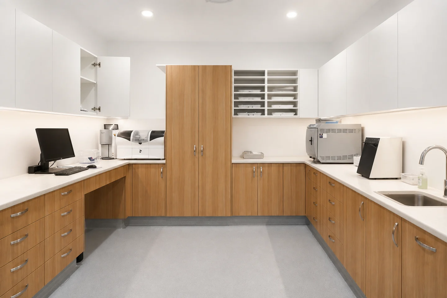 Concept image of a sterilisation room with U-shaped oak cabinetry, equipment and sink