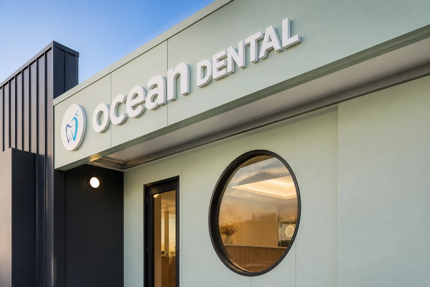 Concept image of the Ocean Dental sign, seafoam facade and circular window